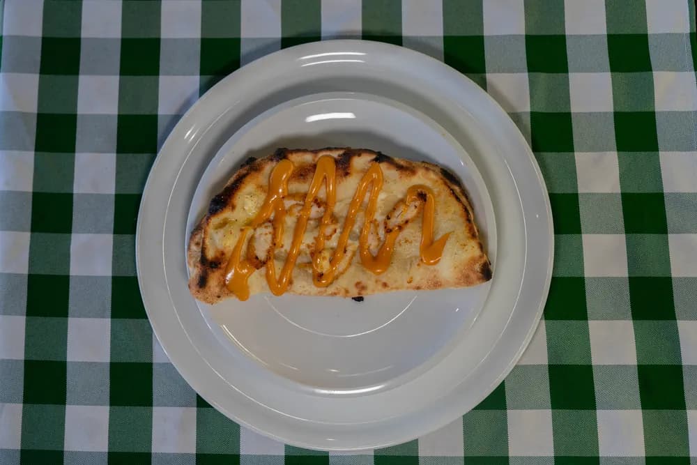 Calzone nappée de sauce sur nappe vichy verte