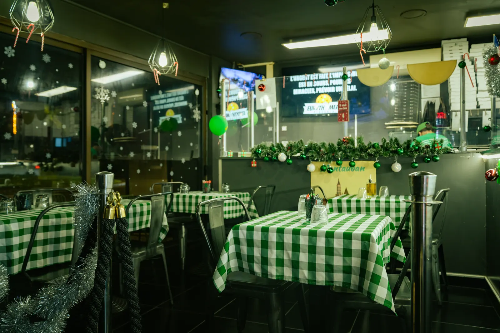 Salle du restaurant Euryth'meal de nuit, tables aux nappes vichy vertes
